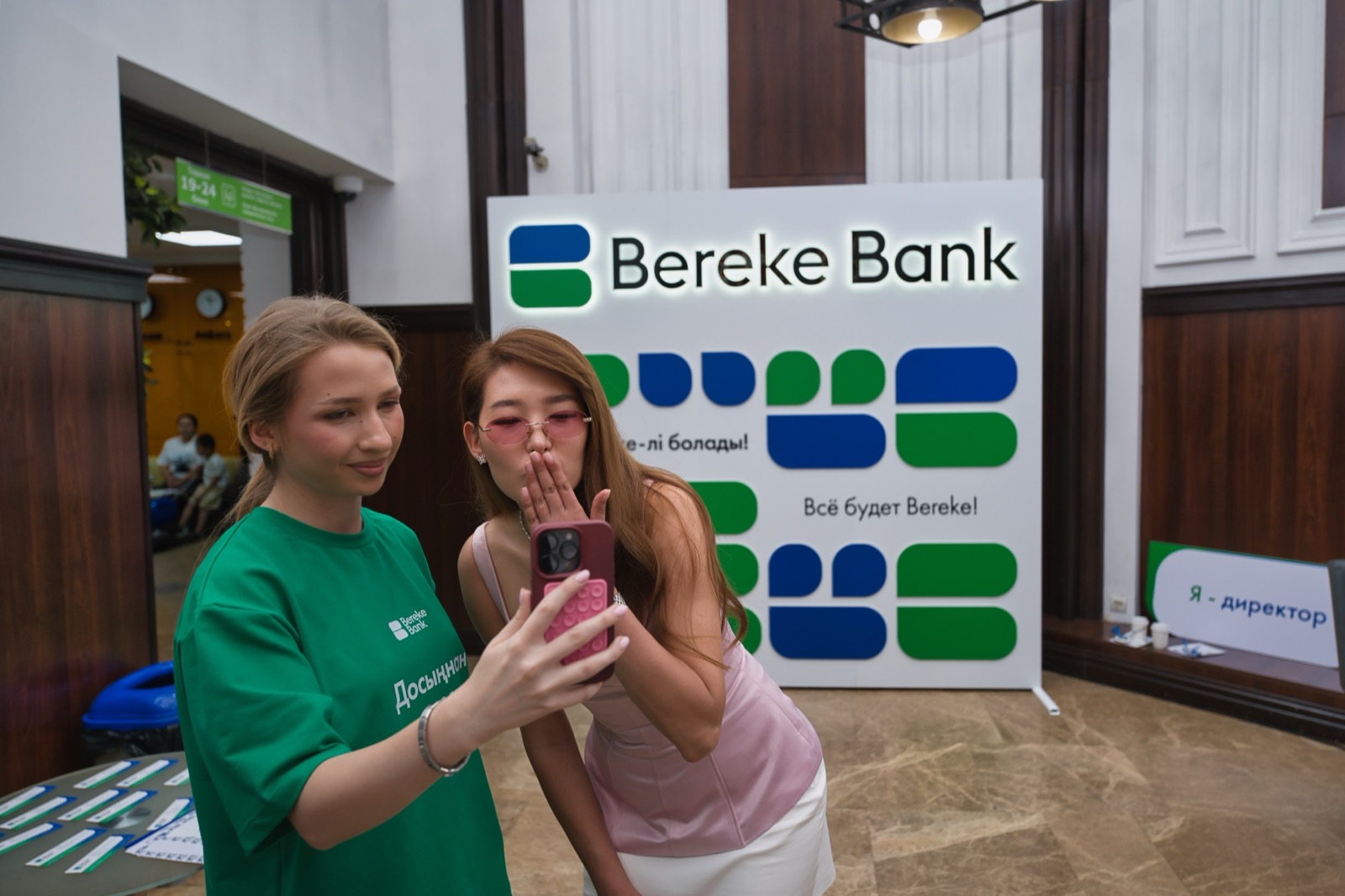 Гостья делает фото с командой Bereke Bank